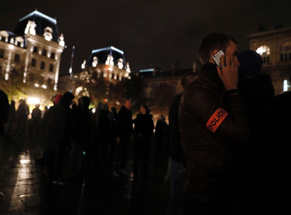 A French police officer talks on his mobile phone outside the Notre-Dame Cathedral in Paris