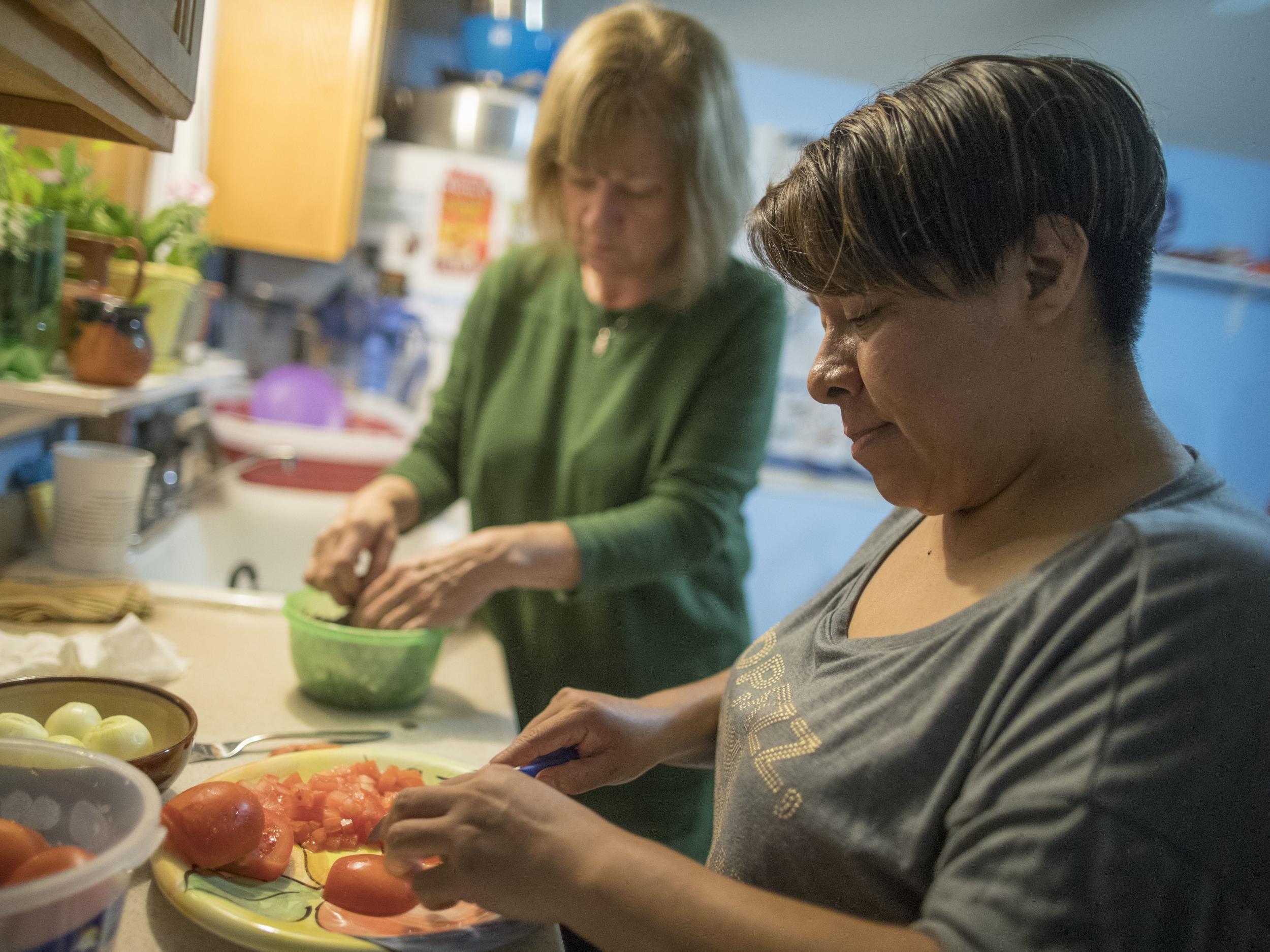Ruth Silverberg, left, helps Maribel Torres prepare dinner at Maribel's home in the Staten Island borough of New York