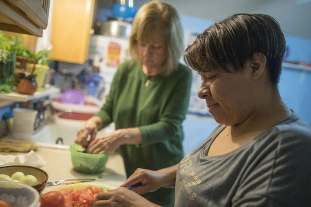 Ruth Silverberg, left, helps Maribel Torres prepare dinner at Maribel's home in the Staten Island borough of New York