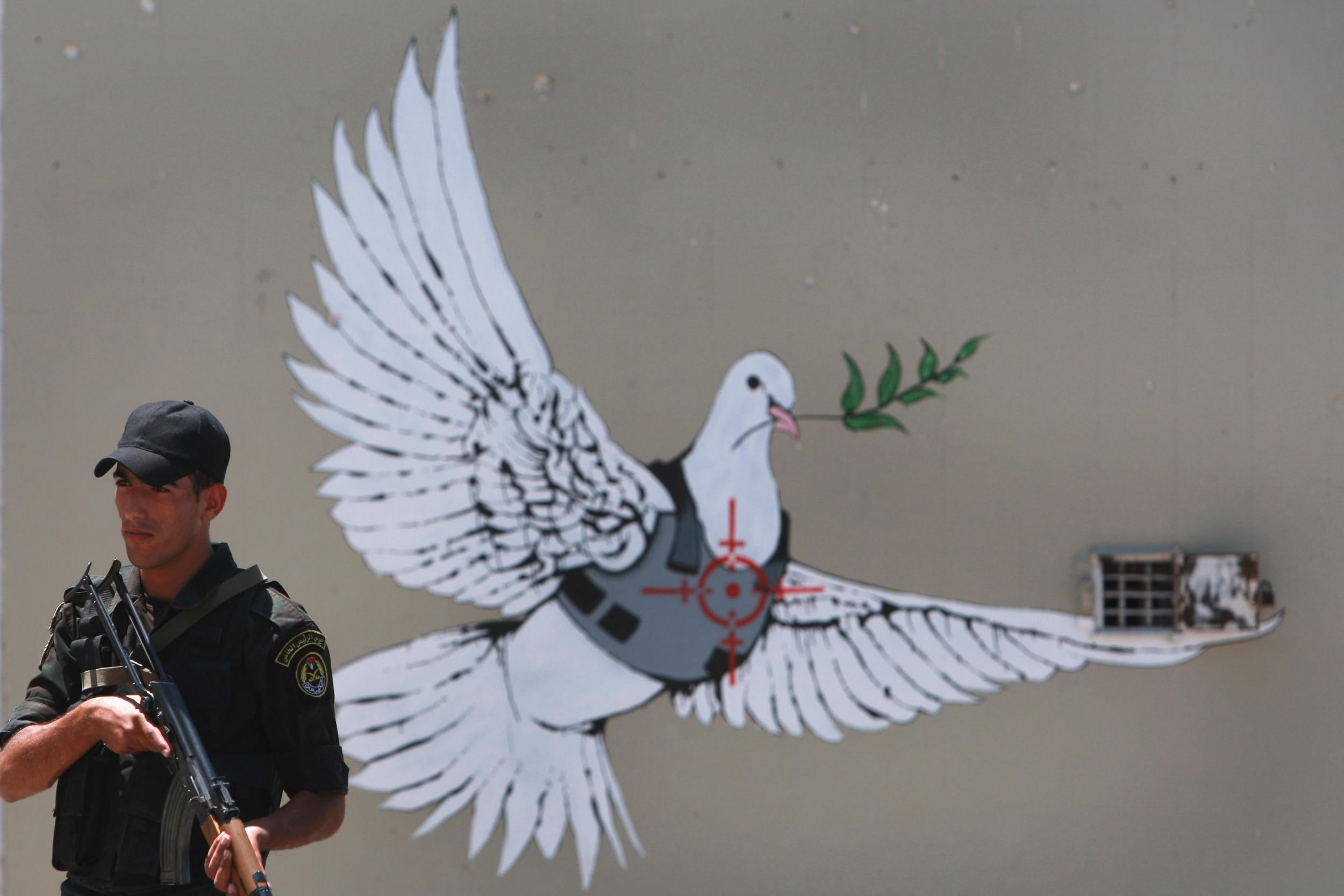 Banksy, whose work adorn parts of Israel’s separation wall, is claimed to have given a family-run guesthouse verbal consent to use his name (Getty)