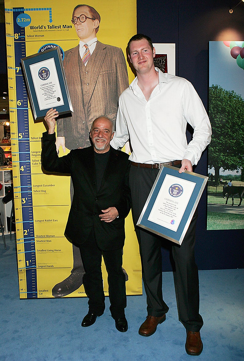 Neil Fingleton (right) poses with author Paulo Coehlo as they are presented with the Guinness World Records for Britain’s tallest man and the most translations of a single title signed by the author in one sitting (Getty)