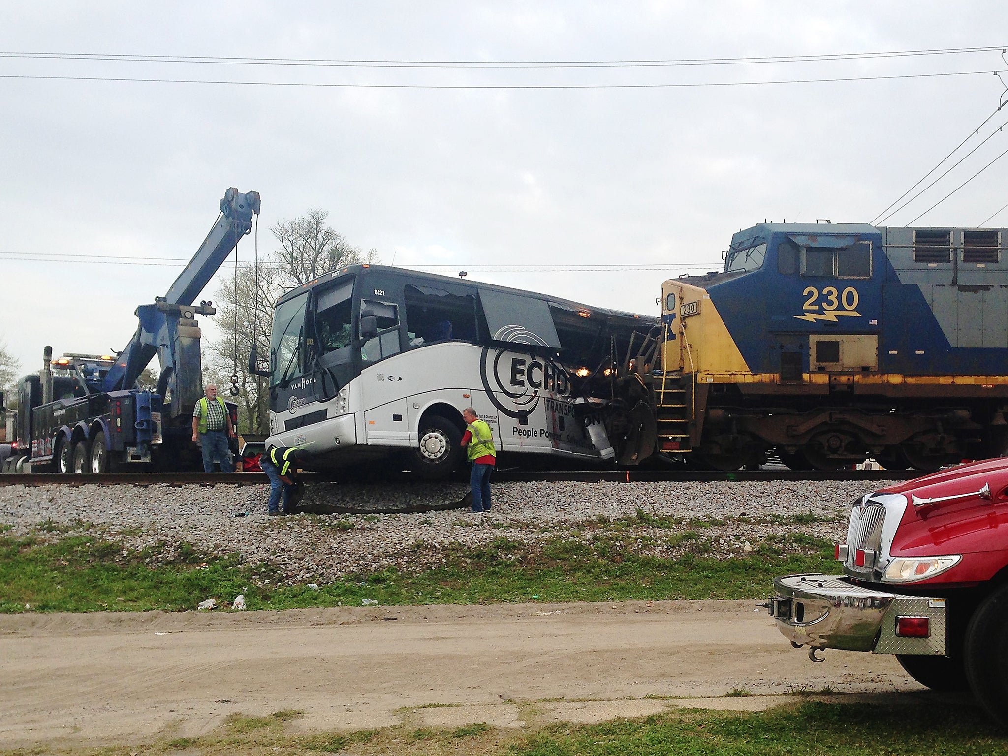 Men prepare to move a charter bus after a freight train crashed into the bus in Biloxi, Mississippi