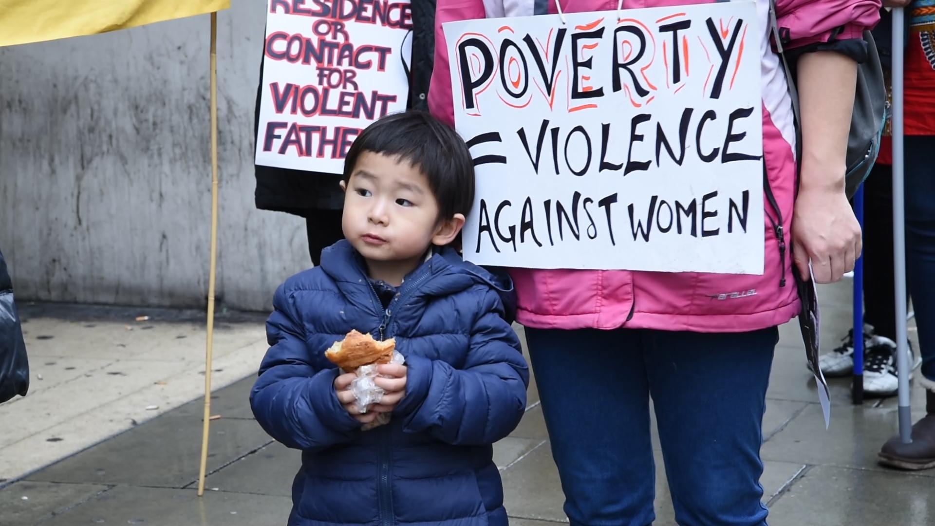 Little boy has a snack while at the protest with his mother