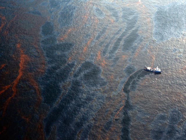 A boat works to collect oil that has leaked from the Deepwater Horizon wellhead in the Gulf of Mexico