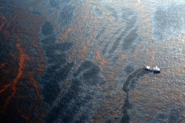 A boat works to collect oil that has leaked from the Deepwater Horizon wellhead in the Gulf of Mexico