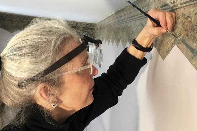 Restoration expert Margaret Saliske works on hand-painted borders at the home of artist Thomas Cole, in Catskill, New York