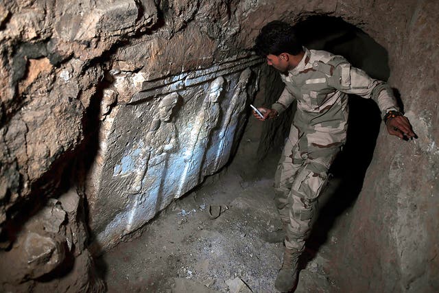 An Iraqi soldier can be seen exploring one of the recently found tunnels beneath the Prophet Jonah's shrine