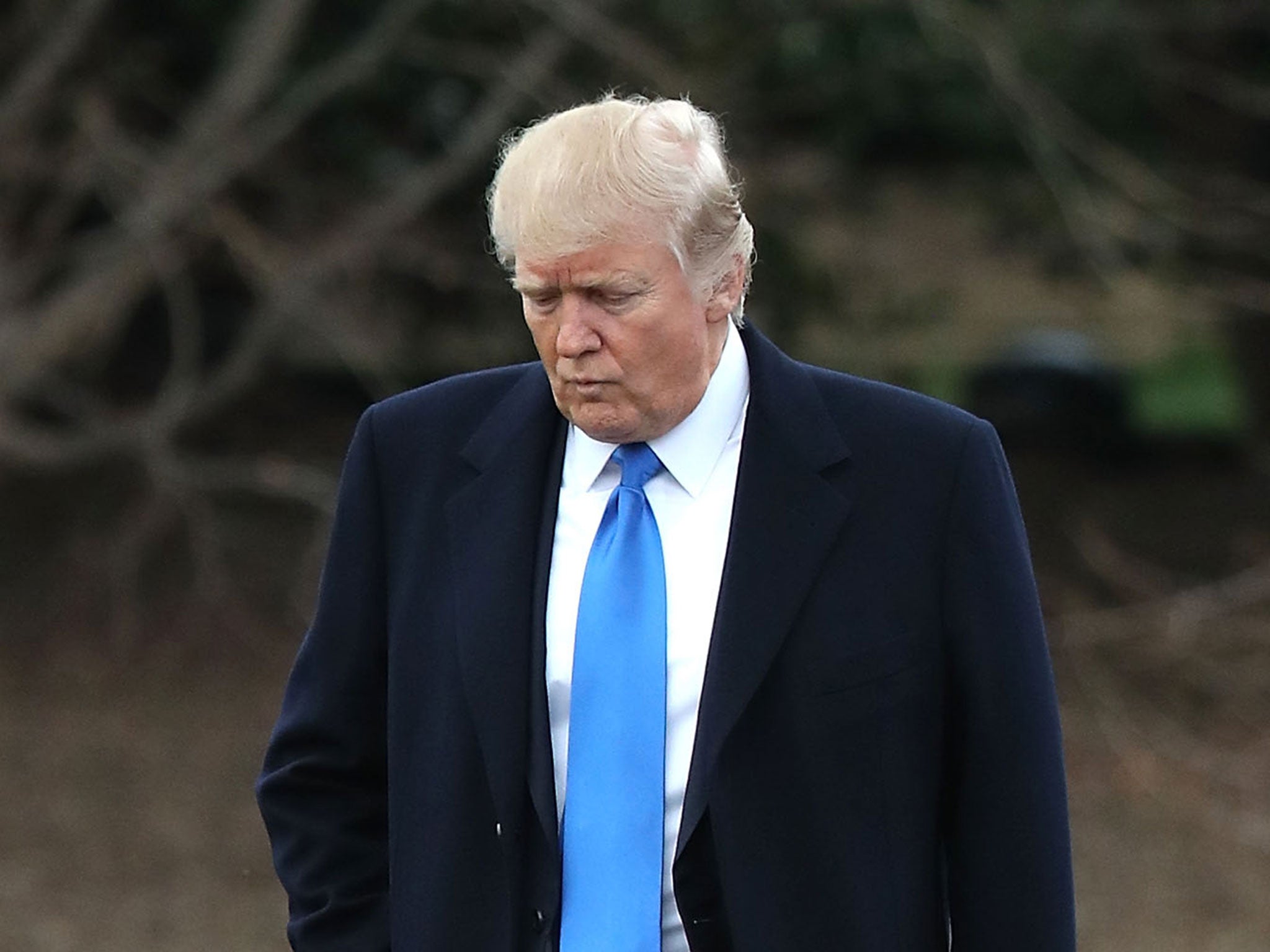 Donald Trump walks toward Marine One while departing from the White House to pay his respects to a Navy Seal killed in a raid in Yemen