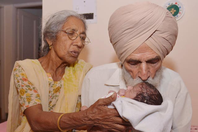 Indian father Mohinder Singh Gill, 79, and his wife Daljinder Kaur, 72, pose for a photograph as they hold their newborn baby boy Arman at their home in Amritsar on May 11, 2016