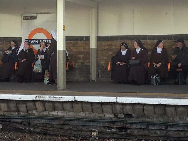 A bemused commuter managed to snap this photo of the seven nuns sitting by the station’s sign