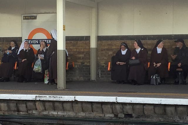 A bemused commuter managed to snap this photo of the seven nuns sitting by the station’s sign