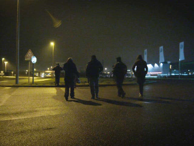 Unaccompanied minors walking in Calais during the night attempting to find a place to try climb aboard lorries without being intimidated by potential people traffickers