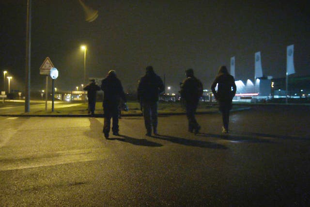 Unaccompanied minors walking in Calais during the night attempting to find a place to try climb aboard lorries without being intimidated by potential people traffickers
