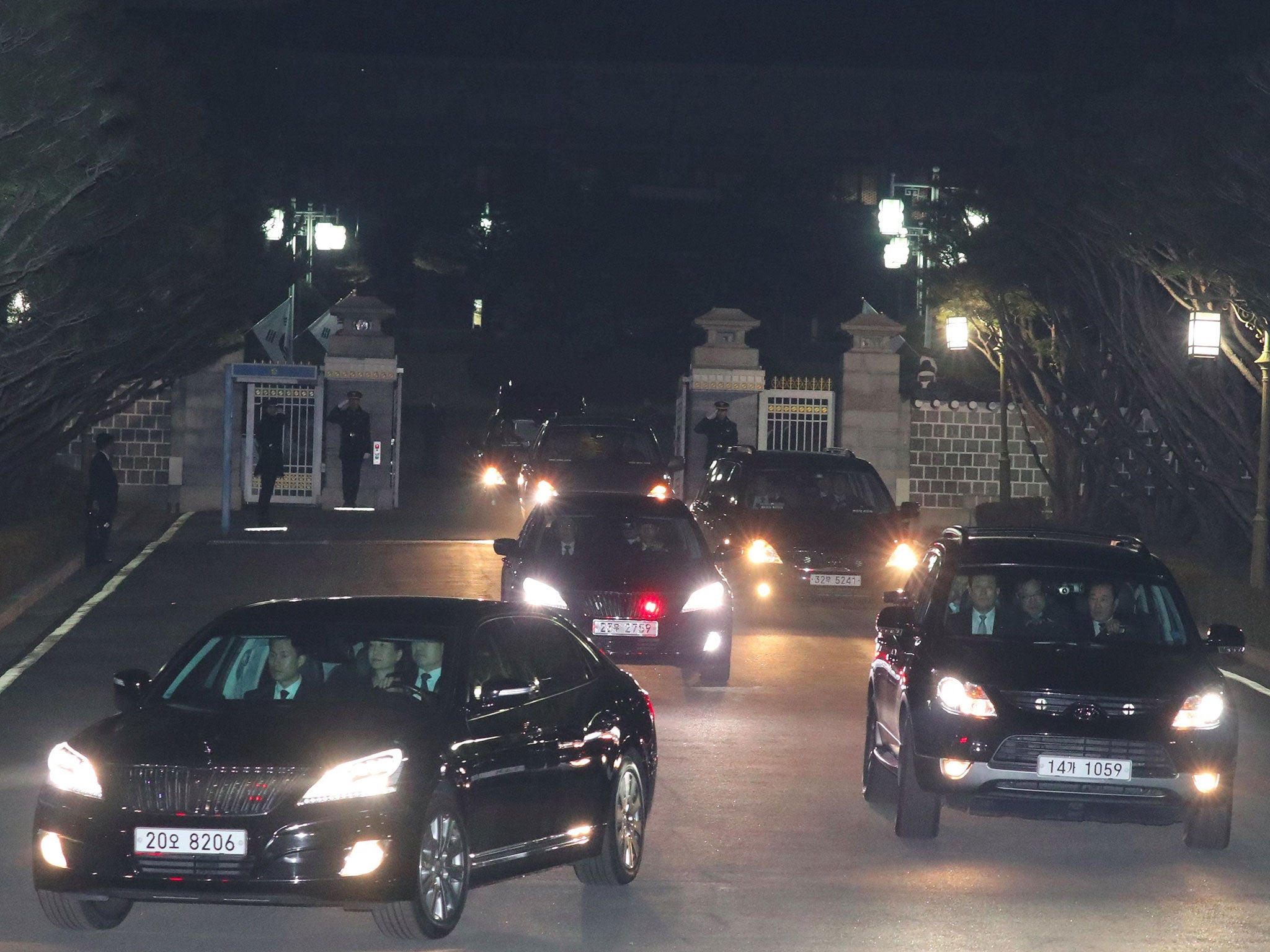 A car (L front) carrying South Korea's impeached ex-president Park Geun-Hye (C in the car) leaves the presidential Blue House in Seoul on 12 March, 2017