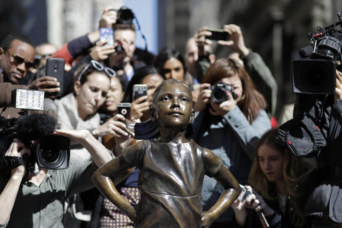 Statue of girl on Wall Street stands opposite a raging bull and is intended to highlight the challenges women face in the financial world