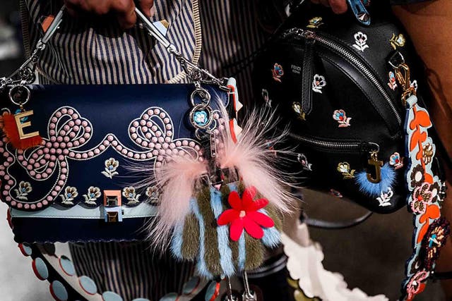 At Fendi, little frame bags were decorated with a clutter of key fobs and furry pom poms