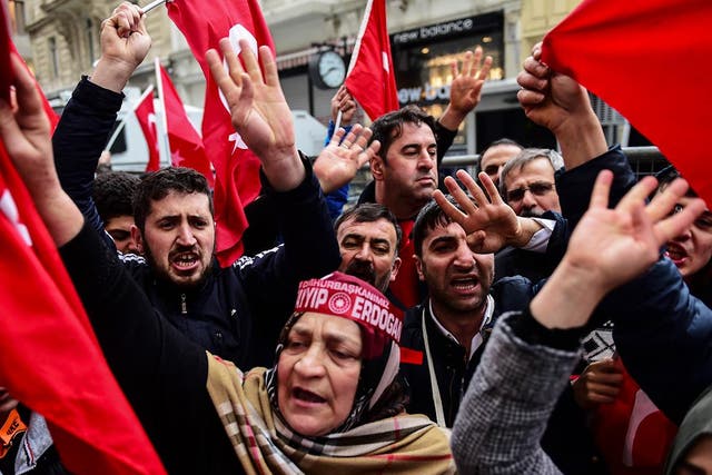 Protesters shout slogans and wave Turkish national flags in front of the Dutch Consulate in Istanbul.