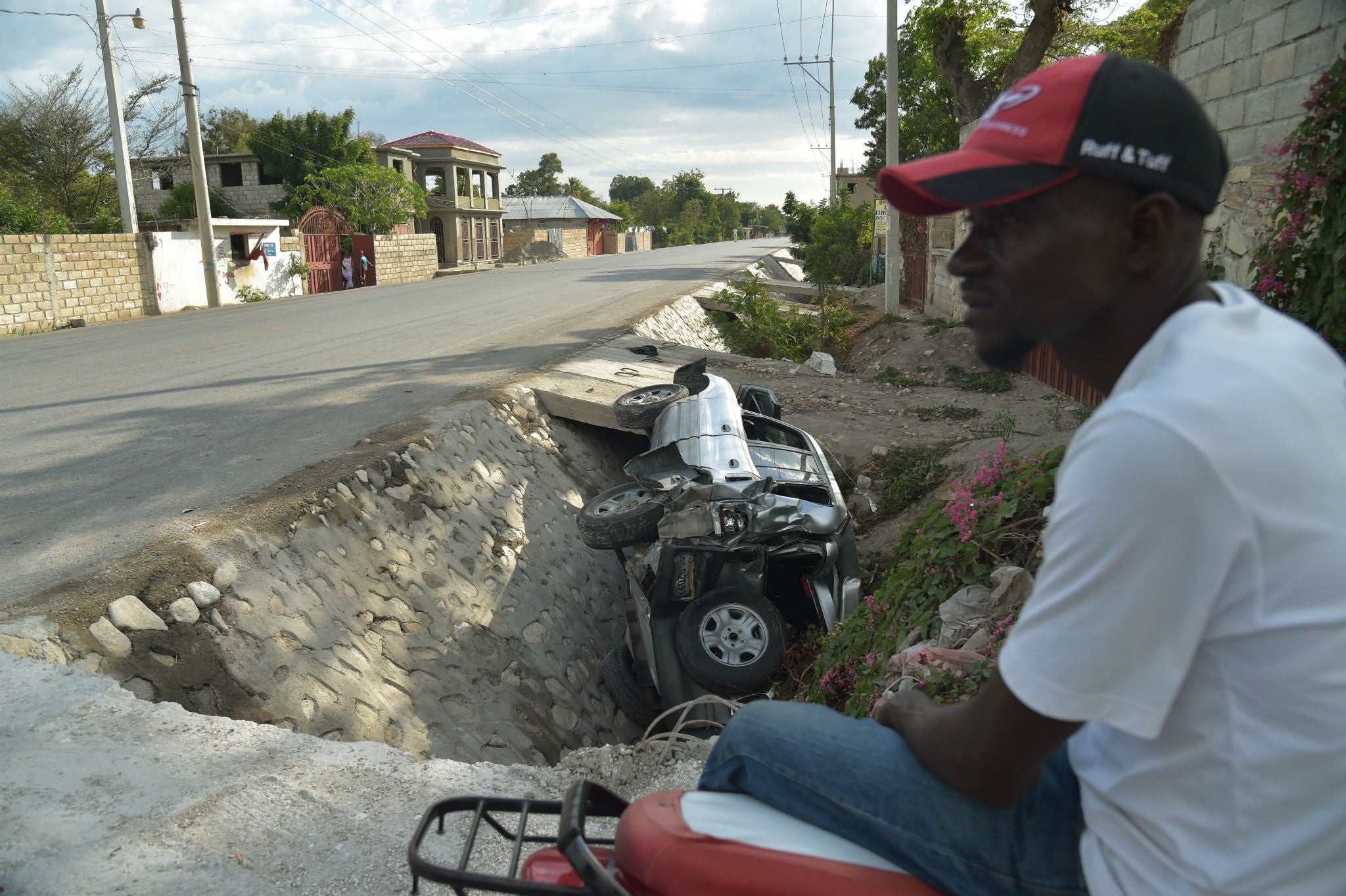 A car damaged by a bus lies on the side of a road yesterday in Gonaives, 150 km (90 miles) northwest of the capital Port-au-Prince