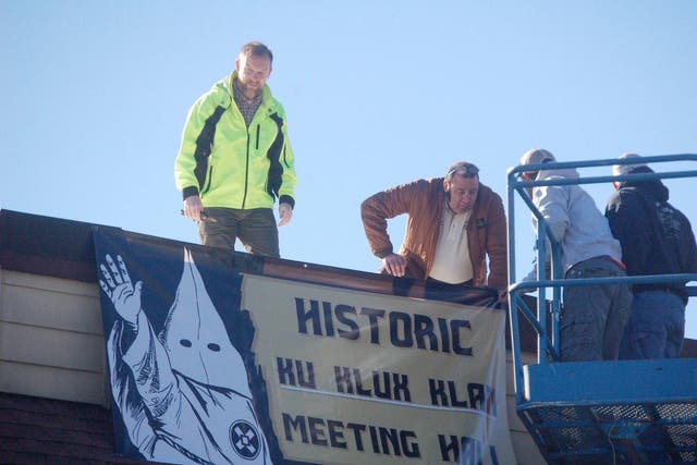 City officials take down a KKK sign from a vacant building downtown in Dahlonega, Georgia, on Feruary. 16. Residents said the banner left them both surprised and scared