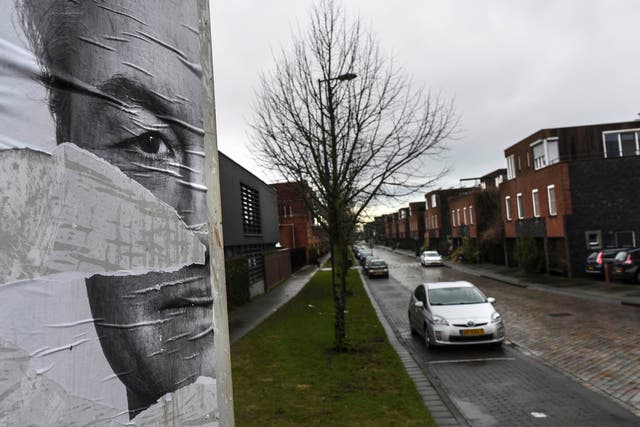 A torn political poster of Geert Wilders, a far right politician, looks over the IJburg neighborhood in Amsterdam