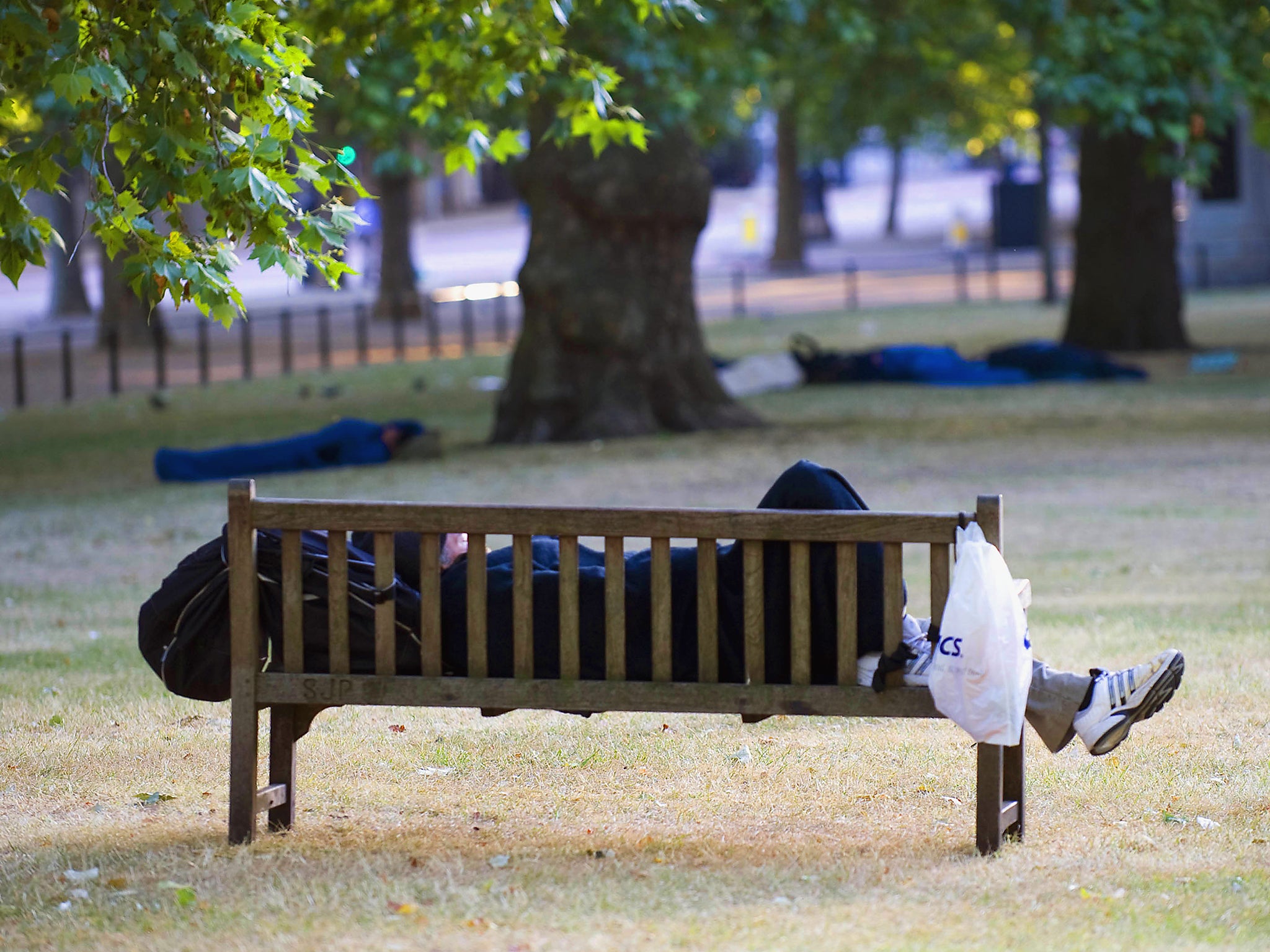 A Homeless person sleeping in St James Park, London, not far from Buckingham Palace.