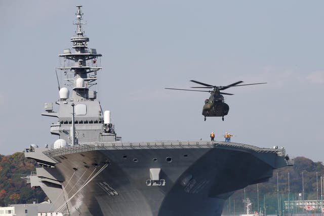 A helicopter lands on the Izumo, Japan Maritime Self Defence Force's (JMSDF) helicopter carrier, at JMSDF Yokosuka base in Yokosuka, south of Tokyo