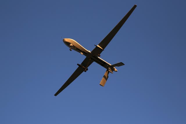 A US unmanned aerial vehicle carrying a Hellfire missile flies over an air base after flying a mission in the Persian Gulf region