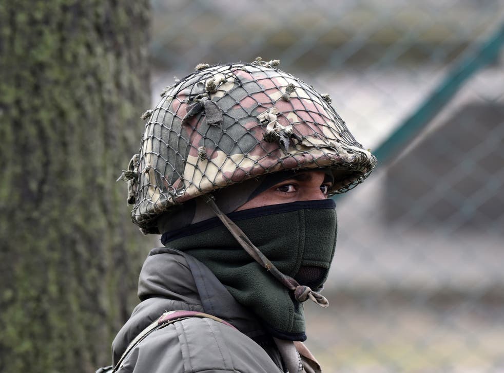An Indian paramilitary trooper stands guard in Kashmir