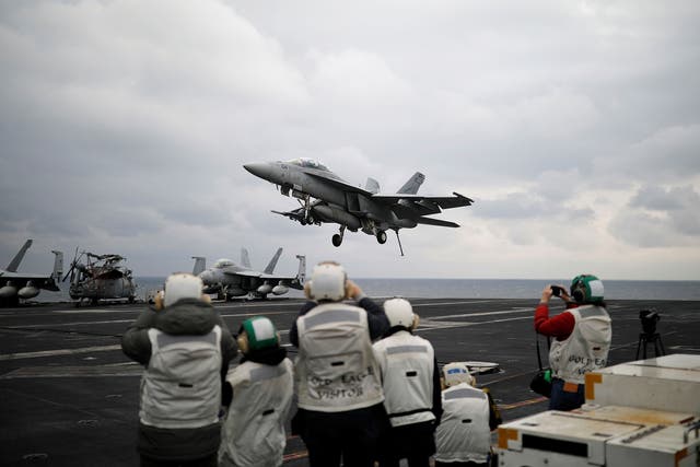 A US F18 fighter jet lands on the deck of the aircraft carrier USS Carl Vinson