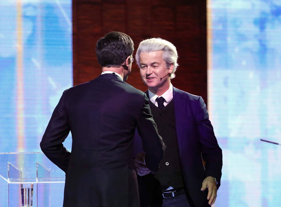 Netherlands' far-right politician Geert Wilders (R) of the PVV party and Netherlands' prime minister Mark Rutte of the VVD Liberal party shake hands before debating on 13 March, 2017