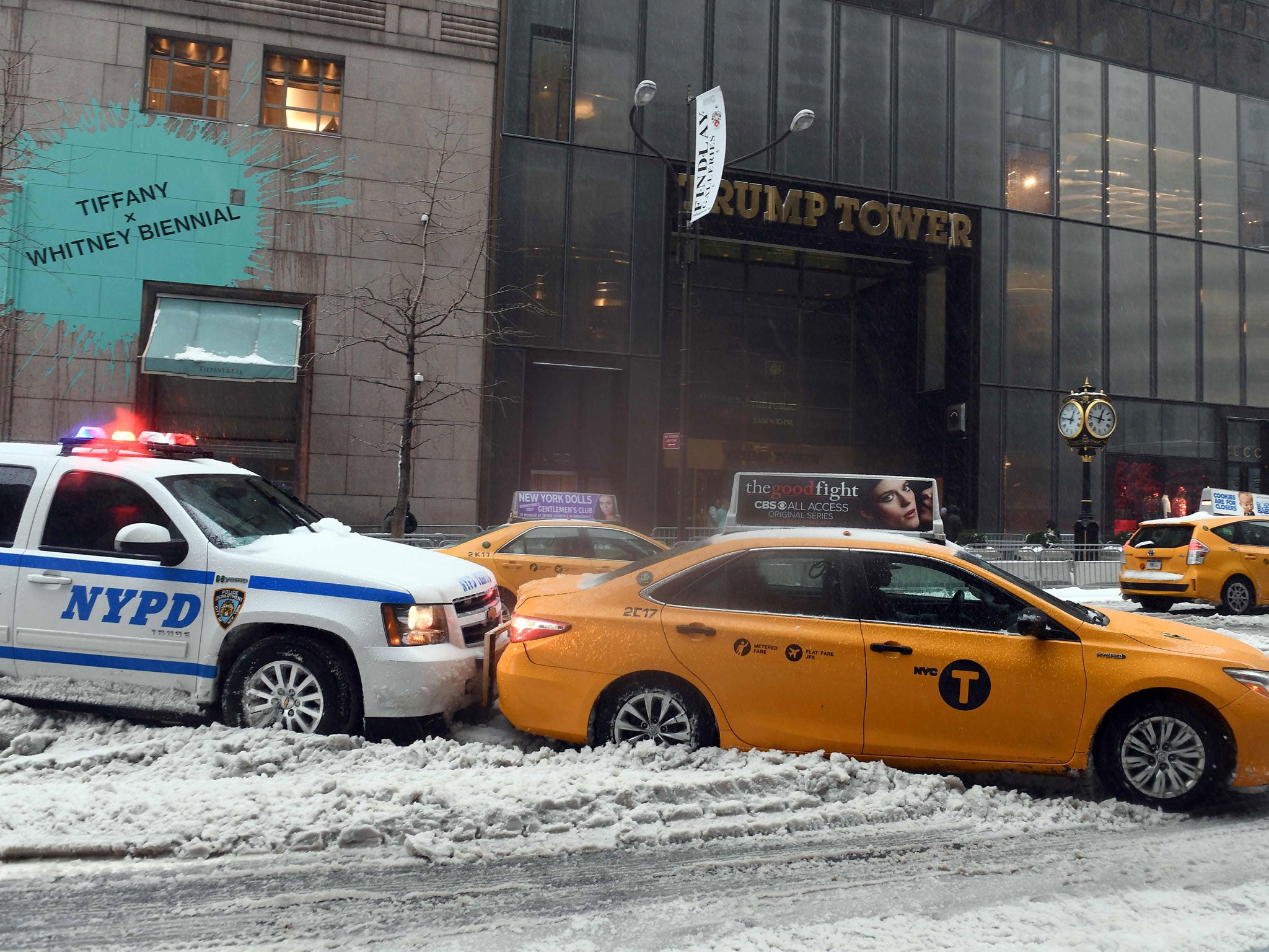 A police car pushes a cab stuck on a snow and sleet-covered street in New York