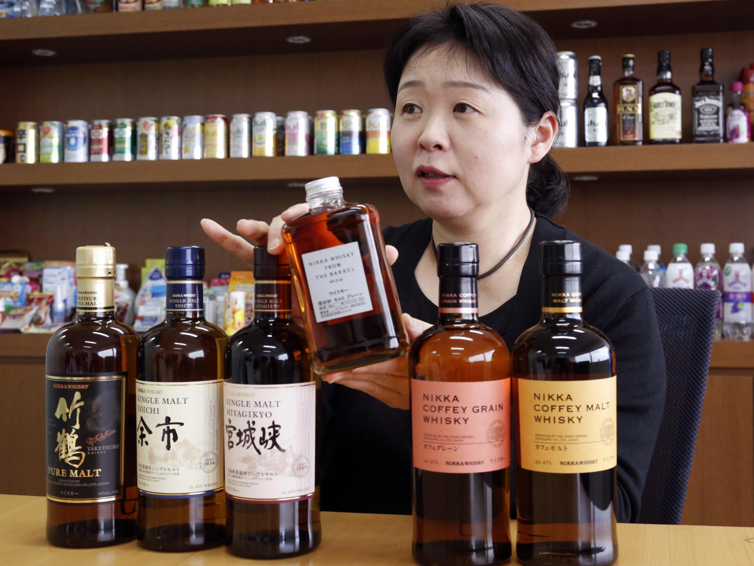 Nikka Whisky's international business development manager Emiko Kaji speaks while showing bottles of their whisky at the headquarters of Asahi Breweries in Tokyo