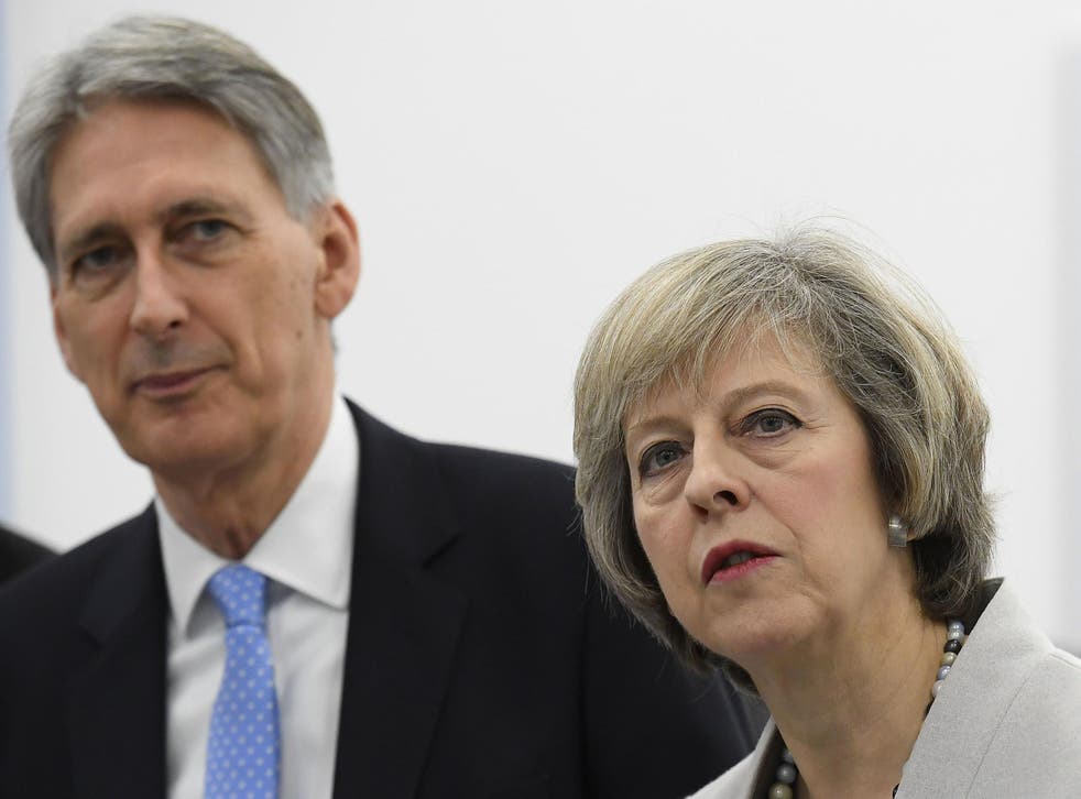 Chancellor Philip Hammond stands with Prime Minister Theresa May