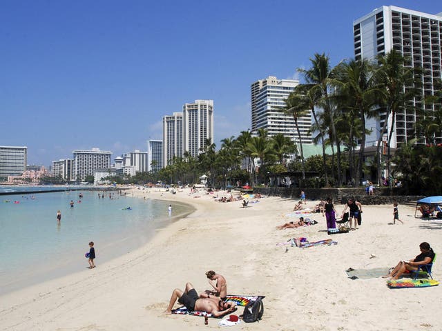 People relax on the beach in Waikiki in Honolulu