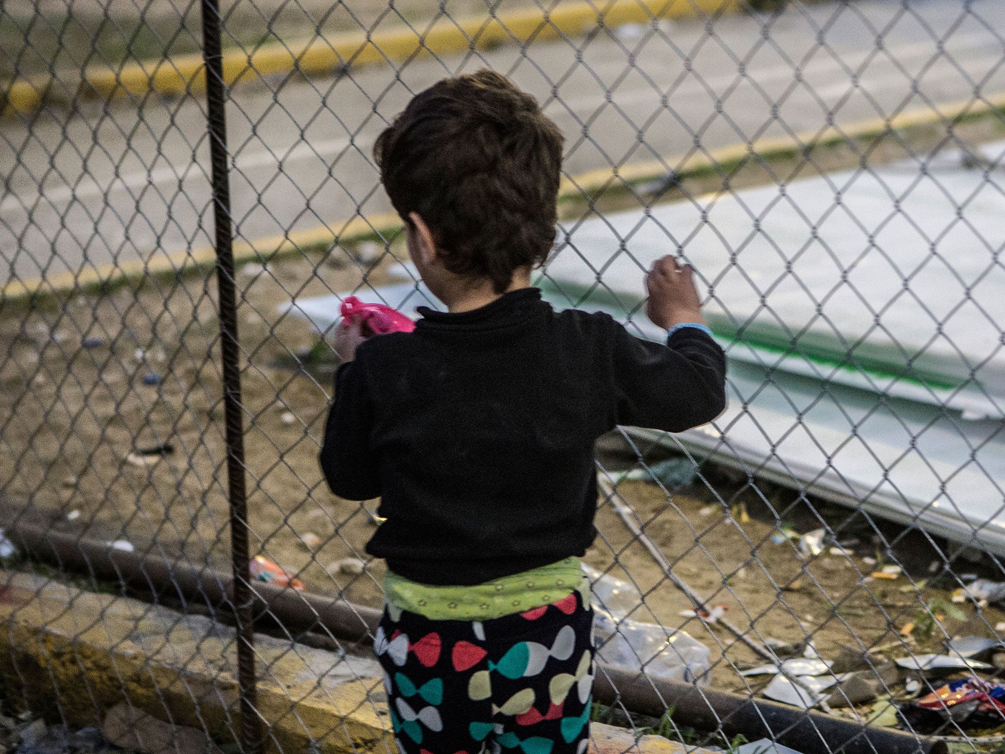A young girl holds the fence in Kara Tepe camp on the Greek island of Lesbos
