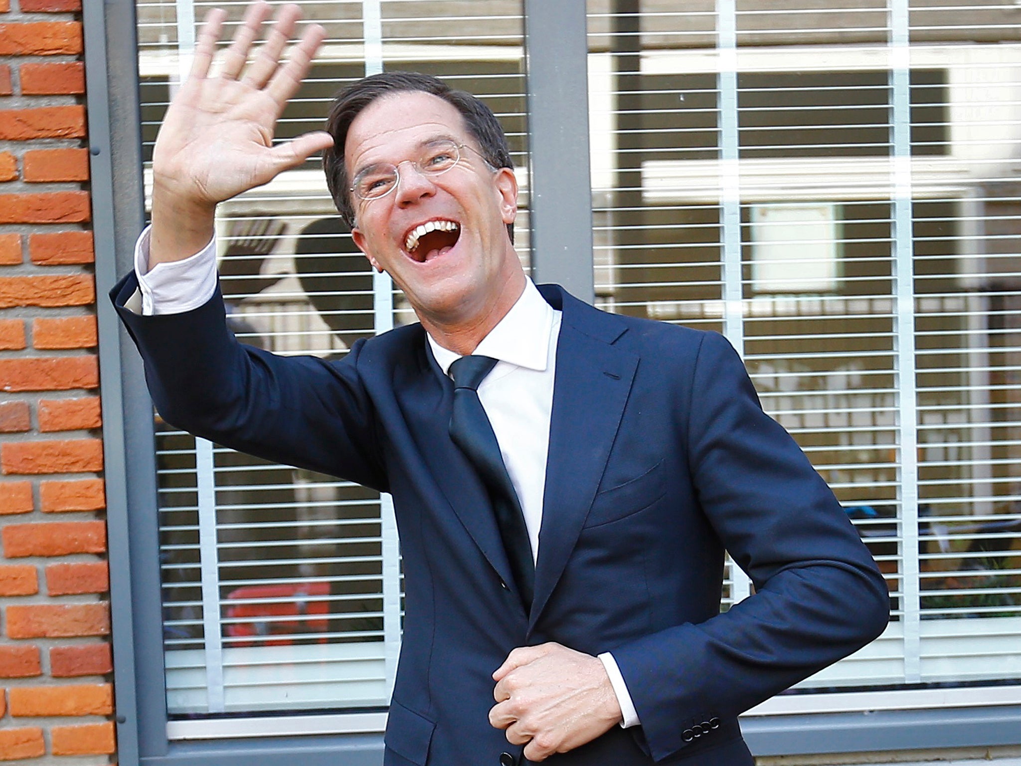 Dutch Prime Minister Mark Rutte of the VVD party waves after voting in the general election