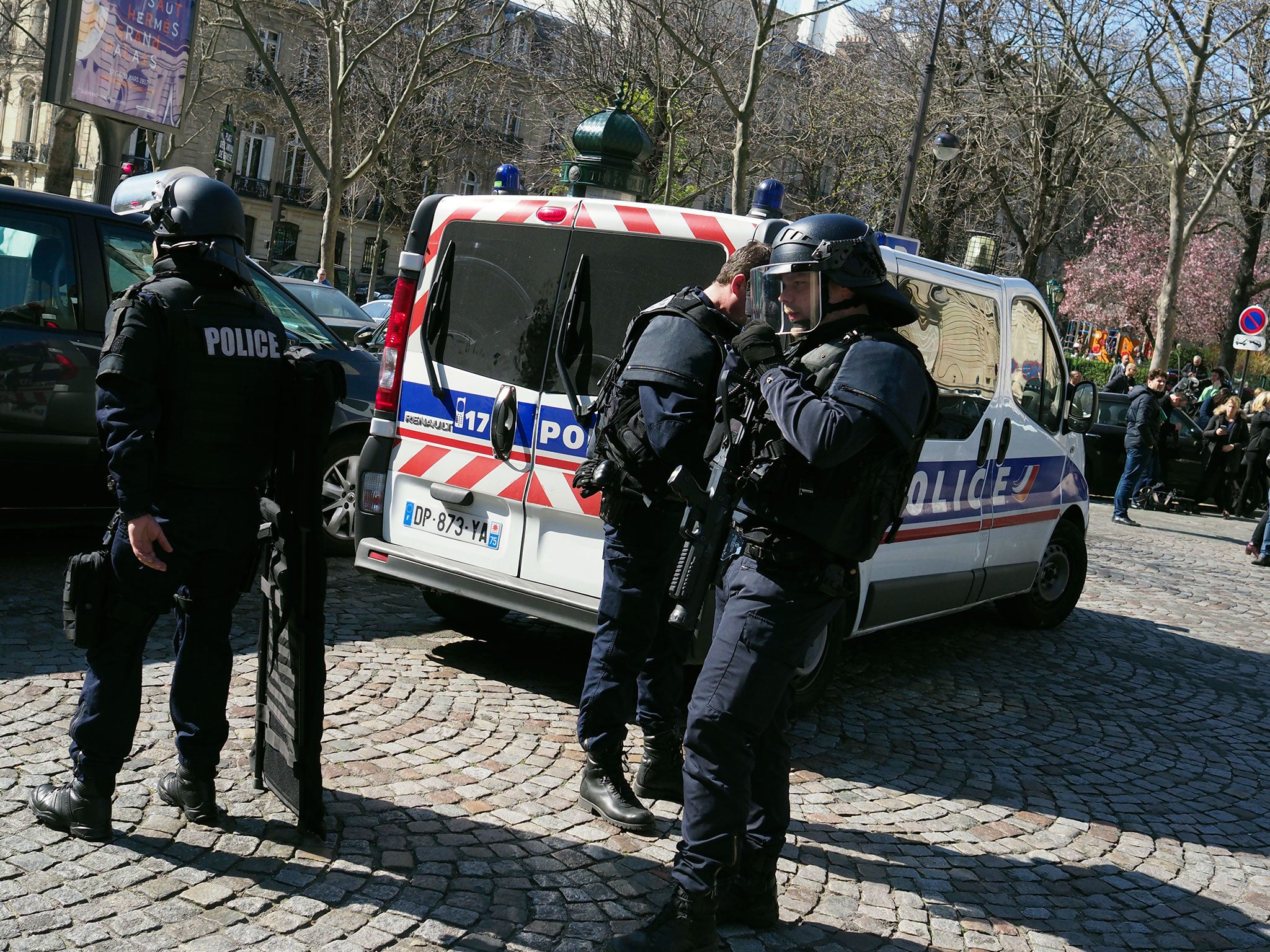 French police officers take position after a parcel bomb exploded at the French office of the International Monetary Fund in Paris on 16 March