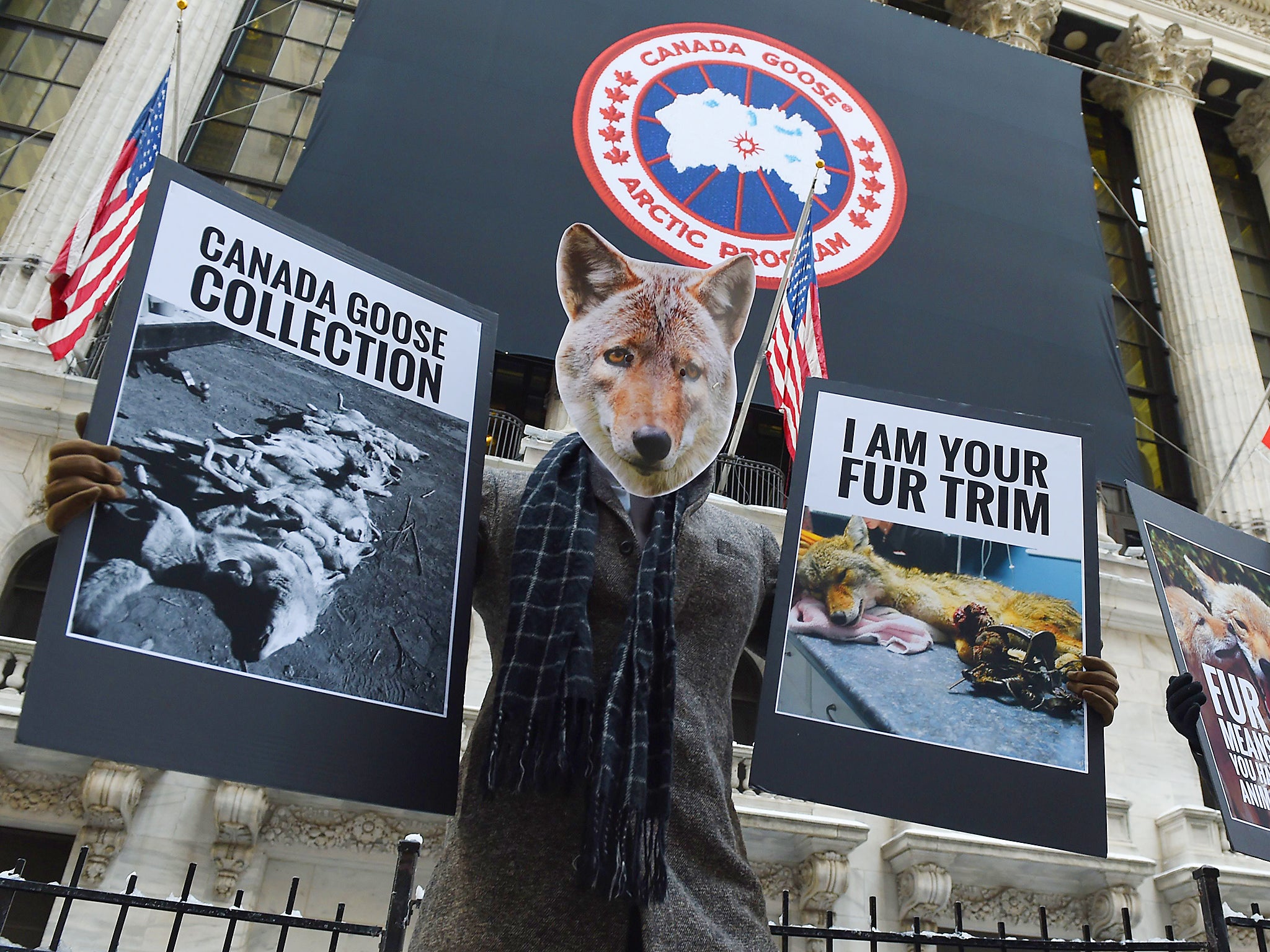 Wearing Coyote masks and business suits and waving signs against Canada Goose and their use of fur, PETA members gather outside the New York Stock Exchange