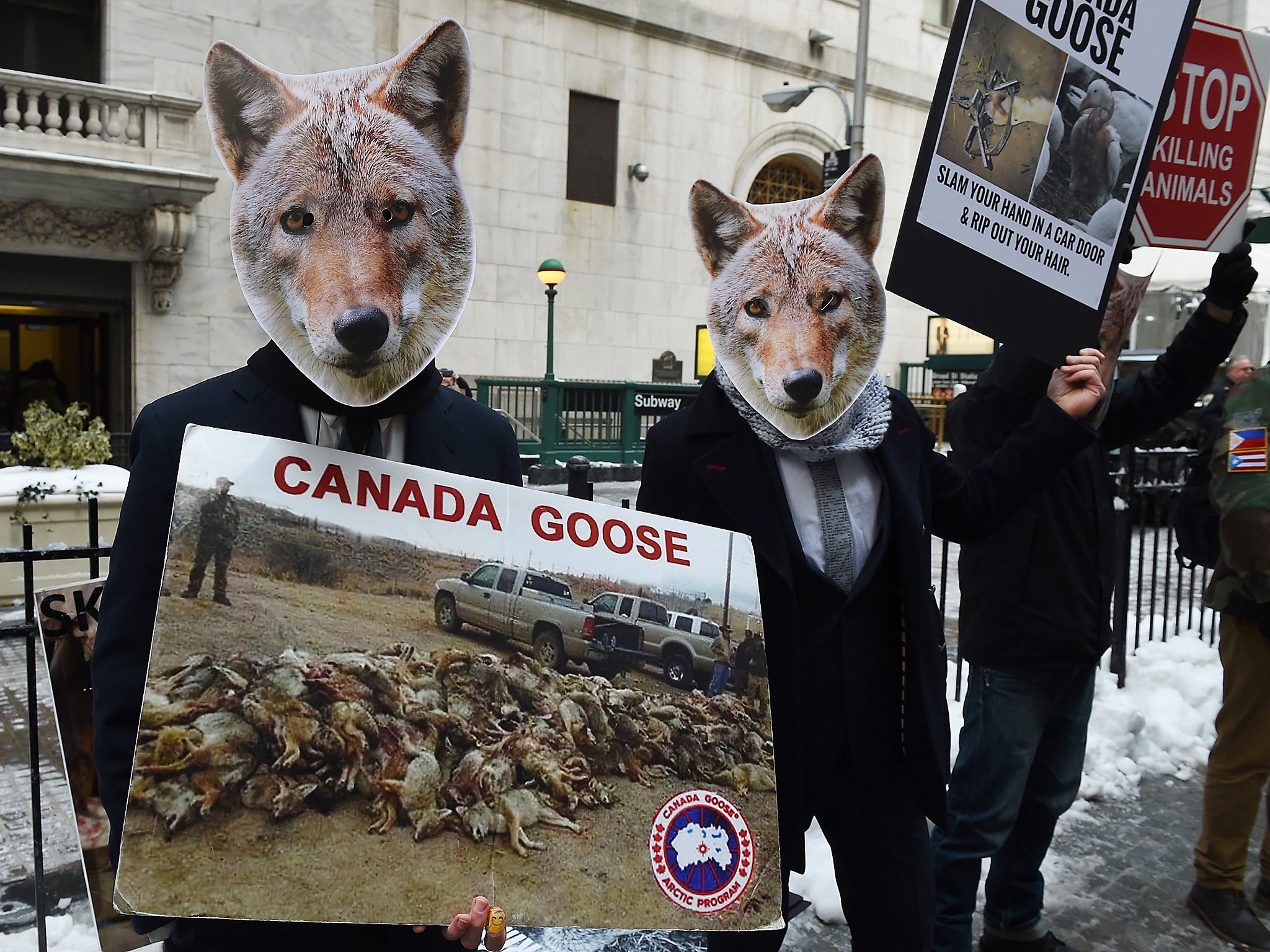 Wearing coyote masks and business suits and waving signs against Canada Goose and their use of fur, PETA members gather outside the New York Stock Exchange