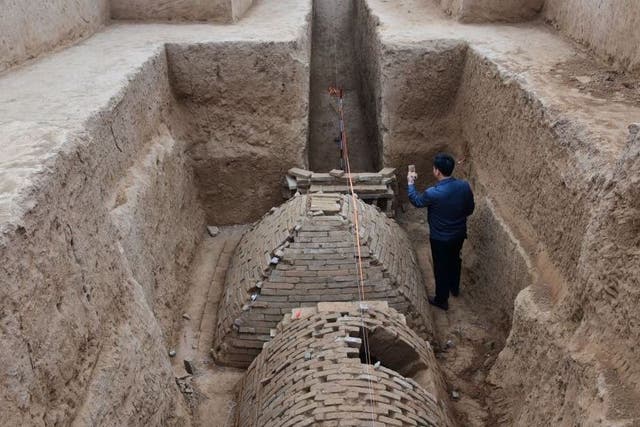 Chinese archaeologist investigates a tomb in the shape of a pyramid