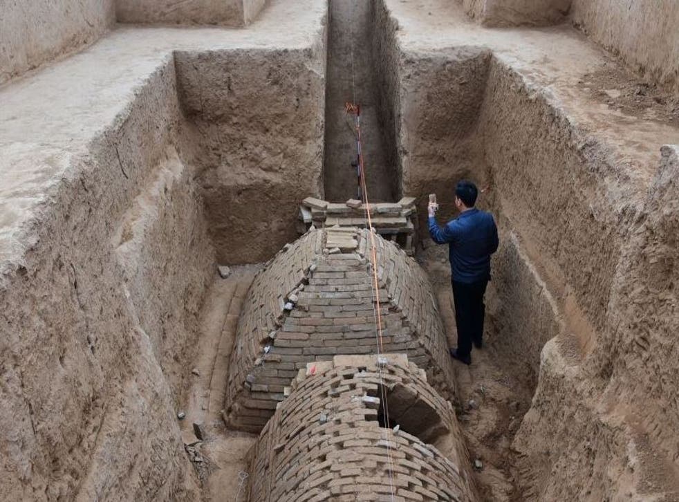 Chinese archaeologist investigates a tomb in the shape of a pyramid