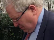 Conservative Party chairman Patrick McLoughlin pushes camera away