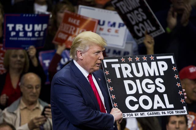 Republican presidential nominee Donald Trump holds a sign supporting coal during a rally at Mohegan Sun Arena in Wilkes-Barre, Pennsylvania