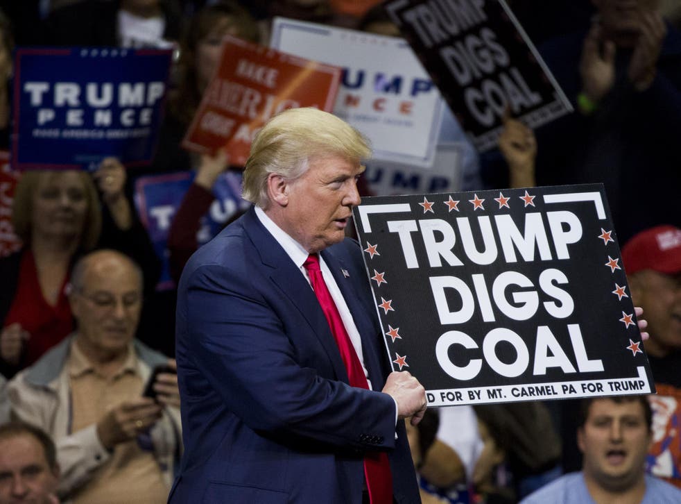 Republican presidential nominee Donald Trump holds a sign supporting coal during a rally at Mohegan Sun Arena in Wilkes-Barre, Pennsylvania