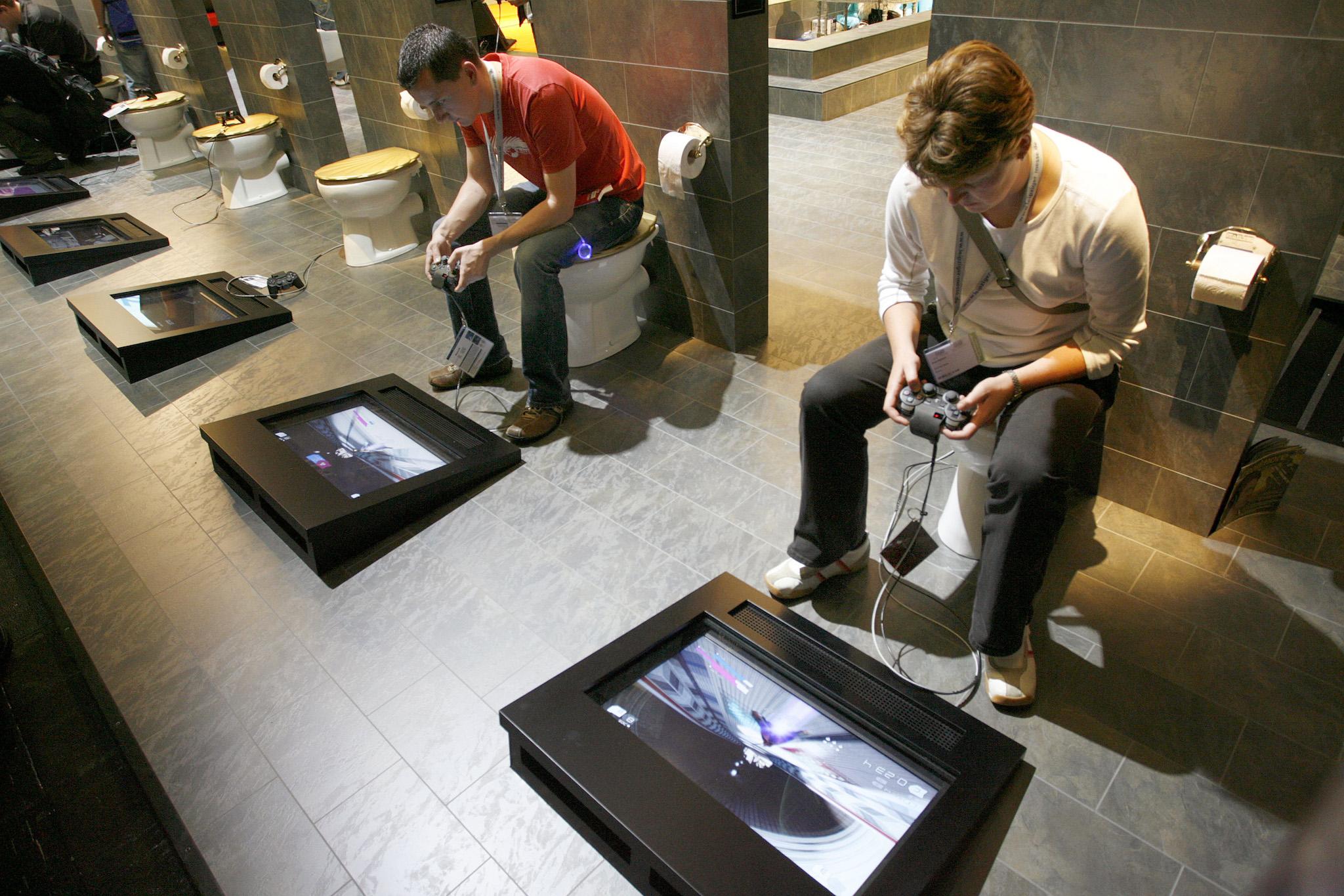Visitors sit on toilet seats to play with Playstation 3 at an exhibition stand of Japanese Sony company at the Games Convention 2007 fair in the eastern German city of Leipzig August 22, 2007