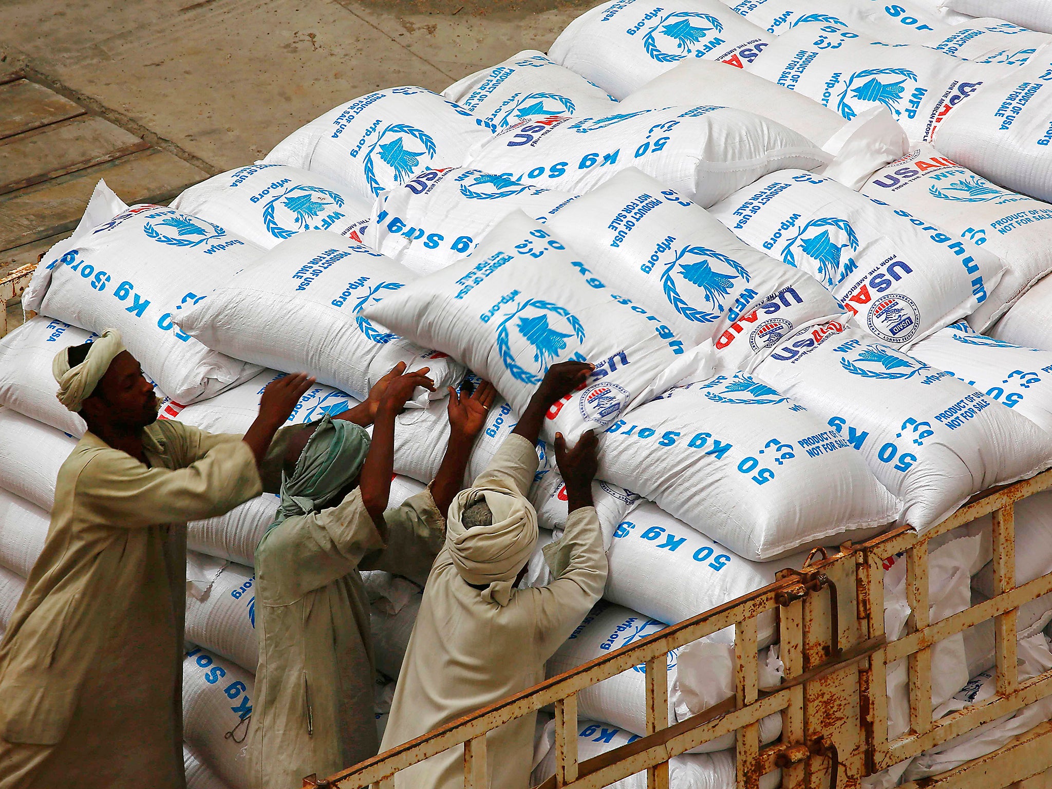 Sudanese workers offload US aid destined for South Sudan from the World Food Programme (WFP) at Port Sudan