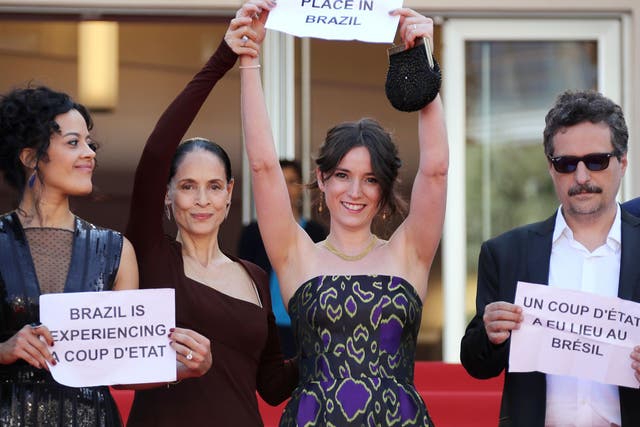 Maeve Jinkings, Sonia Braga, Emilie Lesclaux and Filho hold signs at the world premiere of 'Aquarius' at Cannes days after the Brazilian President Dilma Roussef was suspended