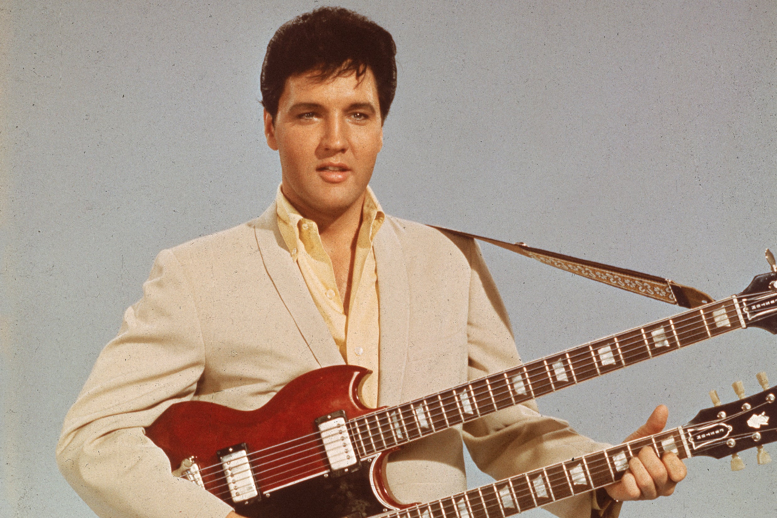 Portrait of American singer and actor Elvis Presley (1935 - 1977) as he holds a twelve string guitar, mid 1950s .