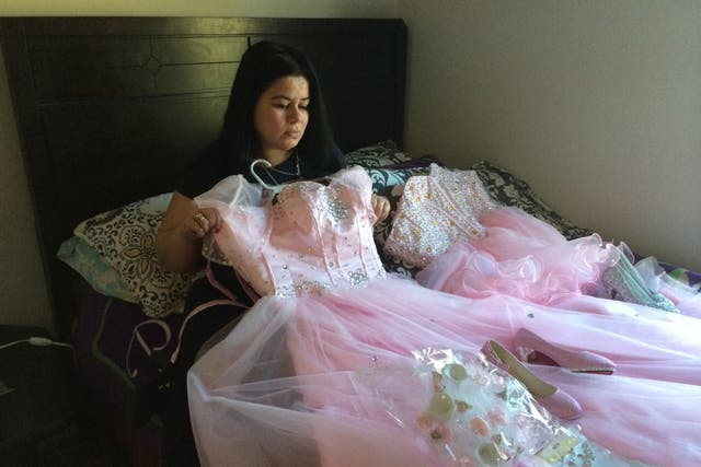 Maria holds the dress her daughter Damaris picked for her quinceañera [15th birthday celebration]