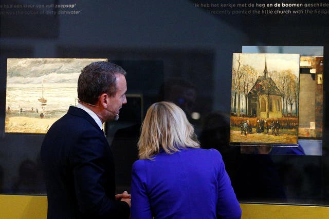 Museum director Axel Ruger and Dutch education minister Jet Bussemaker reveal two recovered paintings by Van Gogh